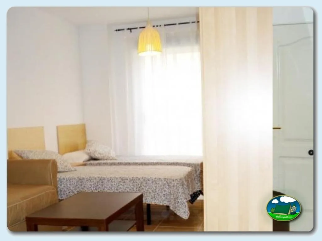 Mobil-home interior con cama y zona de estar del Camping Internacional Las Palmeras, Crevillent (Alicante)