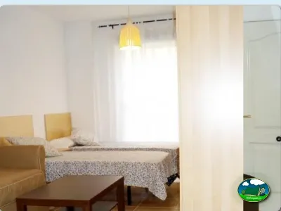 Mobil-home interior con cama y zona de estar del Camping Internacional Las Palmeras, Crevillent (Alicante)