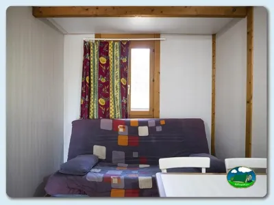 Interior mobil-home con sofá cama y ventana del Camping Mariola, Bocairent (Valencia)