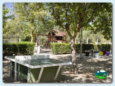 Parcela con mesa de ping pong bajo árboles del Camping Mariola, Bocairent (Valencia)