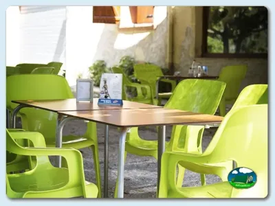 Restaurante con mesas y sillas verde lima del Camping Mariola, Bocairent (Valencia)