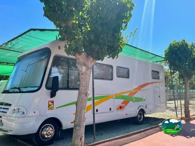 Mobil-home con toldo verde en parcela arbolada del Camping El Jardín, El Campello (Alicante)