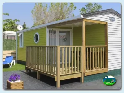 Mobil-home verde con terraza y sombrilla del Camping Armanello, Benidorm – Alicante (Alicante)