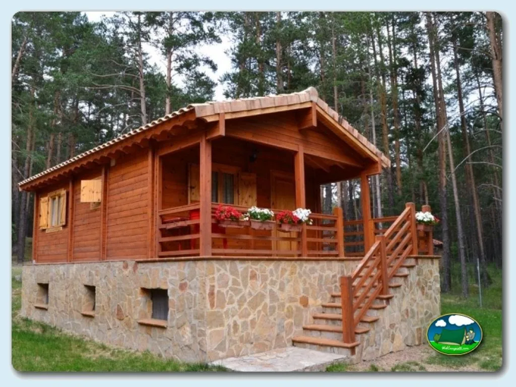 Cabaña de madera con porche en entorno boscoso del Camping Orea, Orea (Guadalajara)