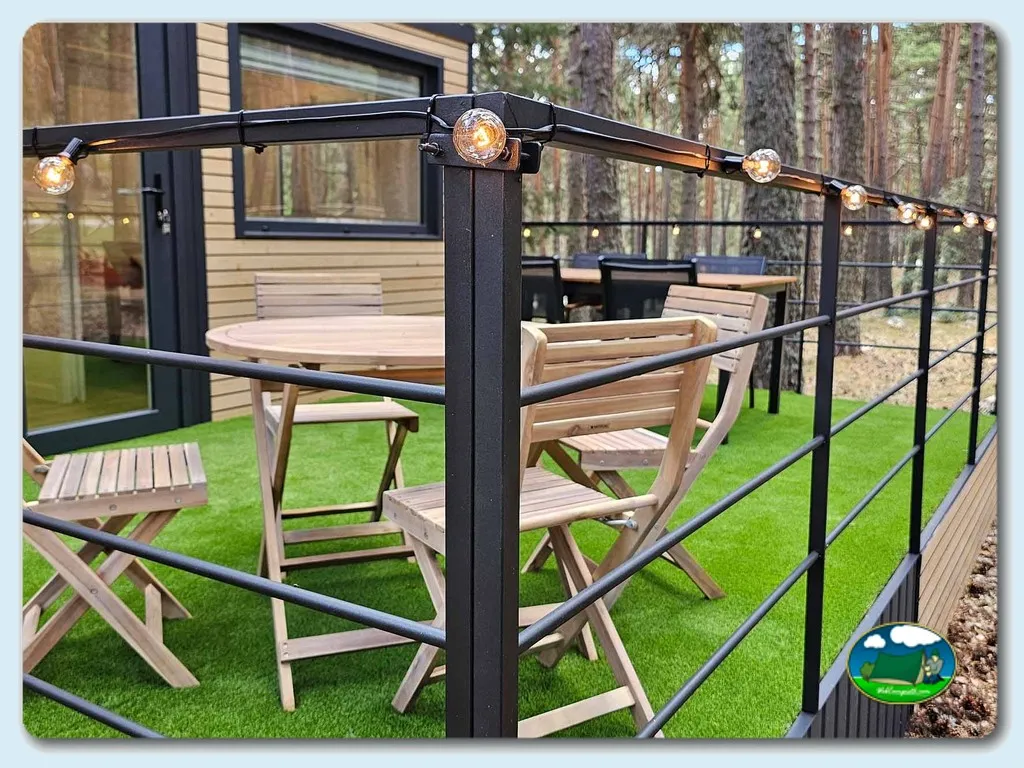Glamping con terraza, mobiliario de madera y luces cálidas entre pinos del Camping Las Corralizas, Bronchales (Teruel)
