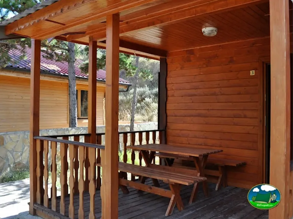 Cabaña de madera con terraza y zona de estar del Camping Las Cabañas, Martin del Rio (Teruel)