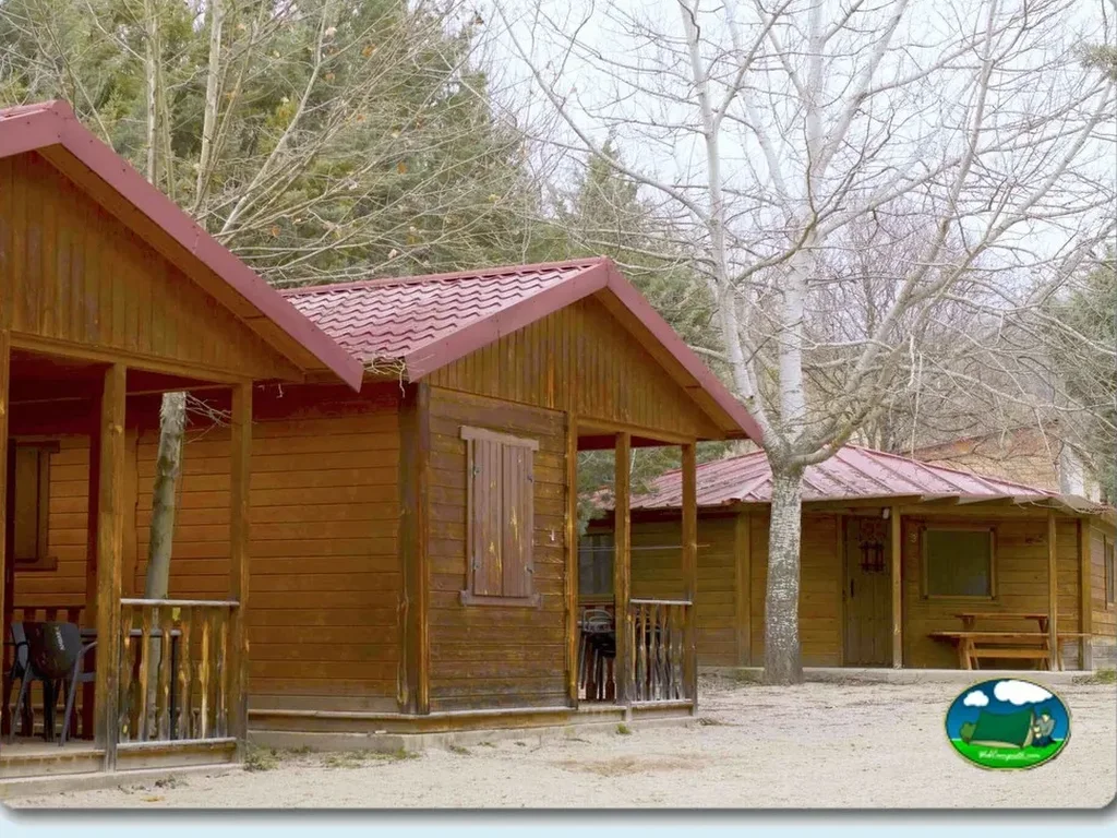 Cabaña de madera con terraza y vistas al bosque del Camping La Morta, Aliaga (Teruel)