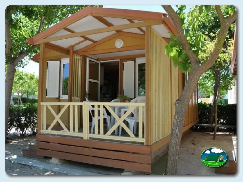 Glamping cabaña de madera con terraza cubierta entre árboles del Camping Pepe, Oliva (Valencia)