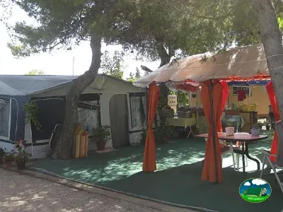 Parcela con mobil-home y toldo rojo del Camping L`Alqueria, Gandía (Valencia)