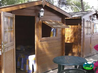 Cabaña de madera con terraza y mesa del Camping L`Alqueria, Gandía (Valencia)