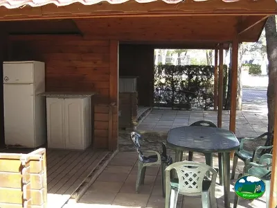 Cabaña de madera con terraza, mesa y nevera del Camping L`Alqueria, Gandía (Valencia)