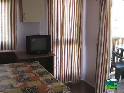 Mobil-home interior con cama y televisión del Camping L`Alqueria, Gandía (Valencia)