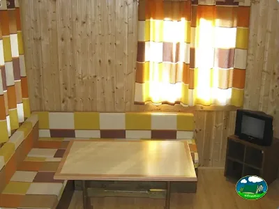 Cabaña interior con sala de estar y mesa del Camping L`Alqueria, Gandía (Valencia)