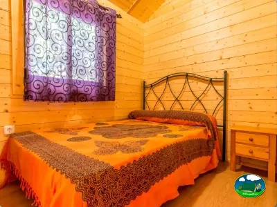 Cabaña interior con cama doble y madera de pino del Camping San Vicente, Xeraco (Valencia)