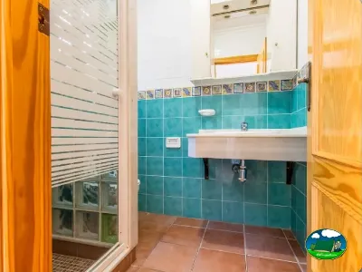 Baño con azulejos turquesas y lavabo del Camping San Vicente, Xeraco (Valencia)