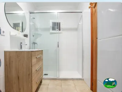 Cuarto de baño con ducha y mueble de madera del Camping San Vicente, Xeraco (Valencia)