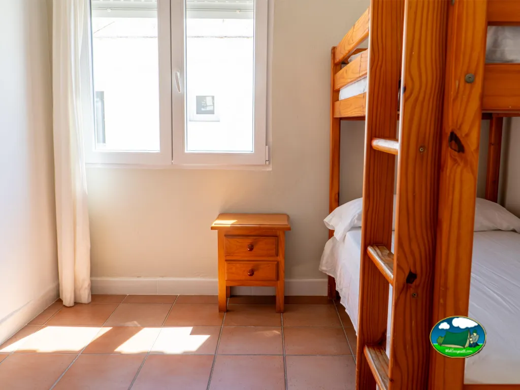 Bungalow interior con literas de madera y luz natural del Camping San Vicente, Xeraco (Valencia)
