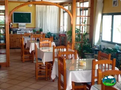 Restaurante interior con mesas de madera del Camping San Vicente, Xeraco (Valencia)