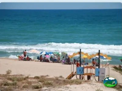 Playa junto al mar con parque infantil y familias en la arena del Camping San Vicente, Xeraco (Valencia)