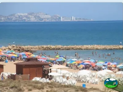 Playa junto al mar con sombrillas y bañistas del Camping San Vicente, Xeraco (Valencia)
