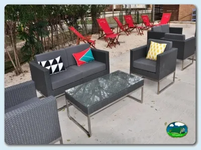 Zona de descanso con sofás y tumbonas junto a árboles del Camping La estanca, Alcañiz (Teruel)