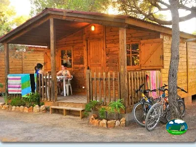 Cabaña de madera con terraza y bicicletas del Camping Cala Nova Playa, Santa Eulalia (Ibiza)