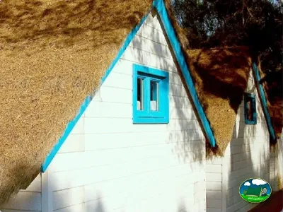 Cabaña con techo de paja y puerta azul turquesa del Camping Son Bou, Alaior (Menorca)