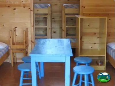 Cabaña interior con mesa y sillas azules del Camping Son Bou, Alaior (Menorca)