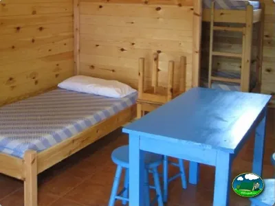 Cabaña interior cama y mesa del Camping Son Bou, Alaior (Menorca)