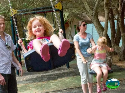 Parque infantil con columpios y niños jugando del Camping Son Bou, Alaior (Menorca)