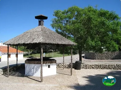 Área de fuego con palapas de paja y asientos del Camping Son Bou, Alaior (Menorca)
