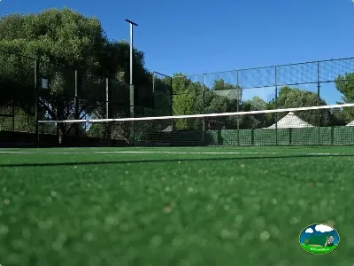Pista de tenis con césped artificial y vistas a la montaña del Camping Son Bou, Alaior (Menorca)