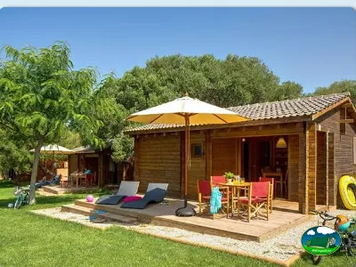 Bungalow de madera con terraza, sombrilla y parcela del Camping Son Bou, Alaior (Menorca)