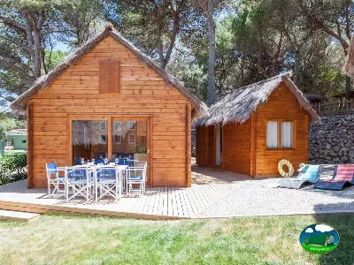 Glamping cabaña de madera con terraza y zona de descanso del Camping Son Bou, Alaior (Menorca)