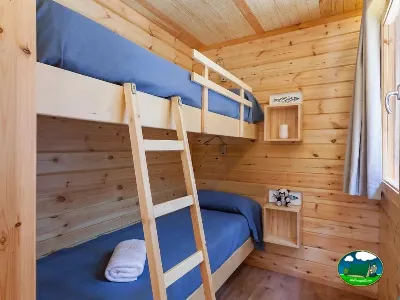 Cabaña de madera con literas y camas individuales del Camping Son Bou, Alaior (Menorca)
