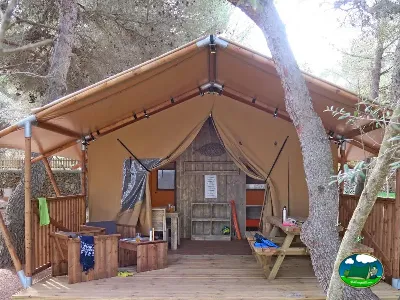 Glamping tienda de acampada entre árboles con terraza de madera del Camping Son Bou, Alaior (Menorca)