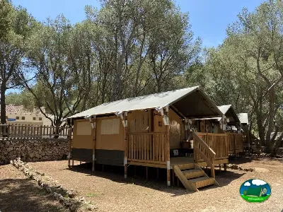 Glamping bajo árboles con terraza de madera del Camping Son Bou, Alaior (Menorca)