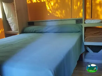 Bungalow interior con cama doble y luz natural del Camping Son Bou, Alaior (Menorca)