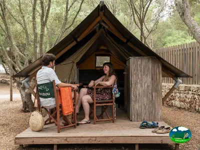 Tipi en bosque con terraza, adulto y niño disfrutando del Camping Son Bou, Alaior (Menorca)