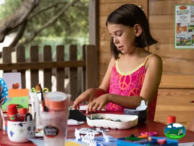 Niña en actividad infantil en cabaña de madera del Camping Son Bou, Alaior (Menorca)