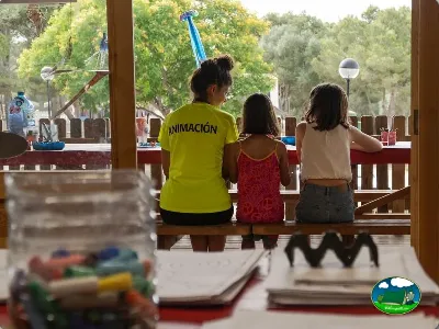 Parque infantil con animador y niños en zona cubierta del Camping Son Bou, Alaior (Menorca)
