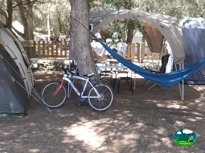 Parcela con tienda de acampada, hamaca y bicicleta del Camping Son Bou, Alaior (Menorca)