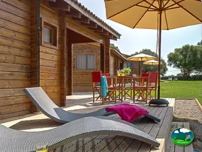 Bungalow de madera con terraza, tumbonas y sombrillas del Camping Son Bou, Alaior (Menorca)
