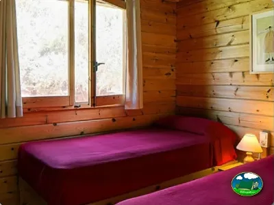 Cabaña interior con cama y ventanas del Camping Son Bou, Alaior (Menorca)
