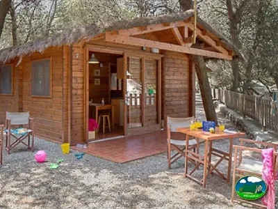 Cabaña de madera con zona de juegos infantil del Camping Son Bou, Alaior (Menorca)