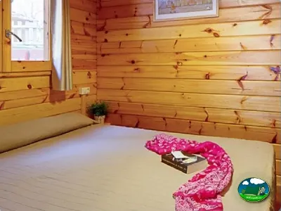 Cabaña de madera interior con cama del Camping Son Bou, Alaior (Menorca)