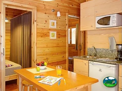 Cabaña interior con cocina equipada y dormitorio del Camping Son Bou, Alaior (Menorca)