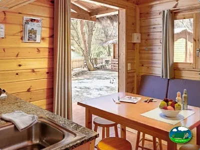 Cabaña de madera con cocina abierta y terraza del Camping Son Bou, Alaior (Menorca)