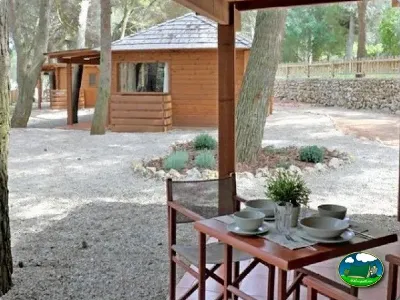 Cabaña de madera con terraza y mesa del Camping Son Bou, Alaior (Menorca)