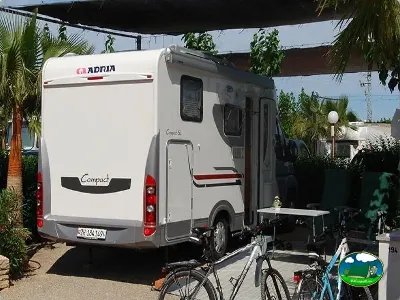 Mobil-home en parcela con sombrilla y bicicletas del Camping Bravoplaya, Ribera de cabanes (Castellón)